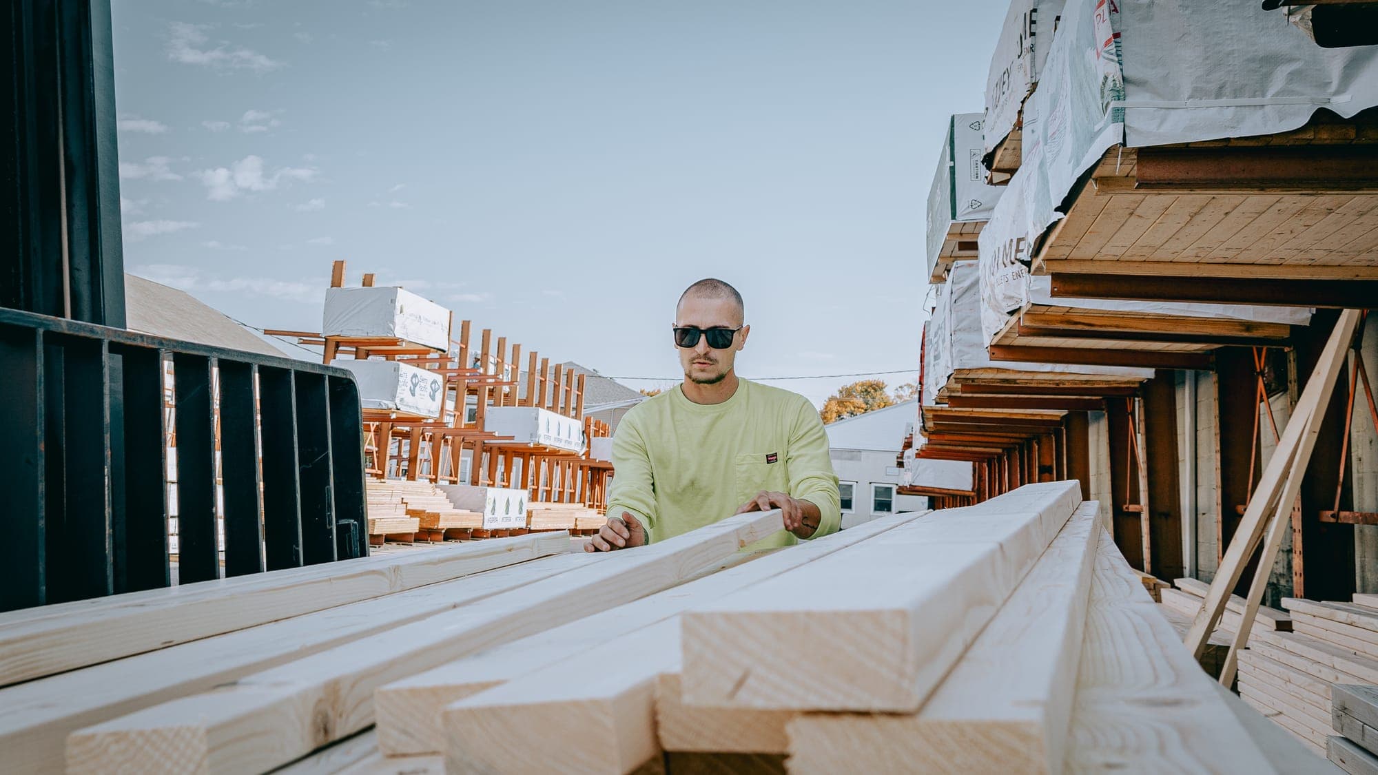 A yard worker checking framing lumber in a building-supply dealer's yard